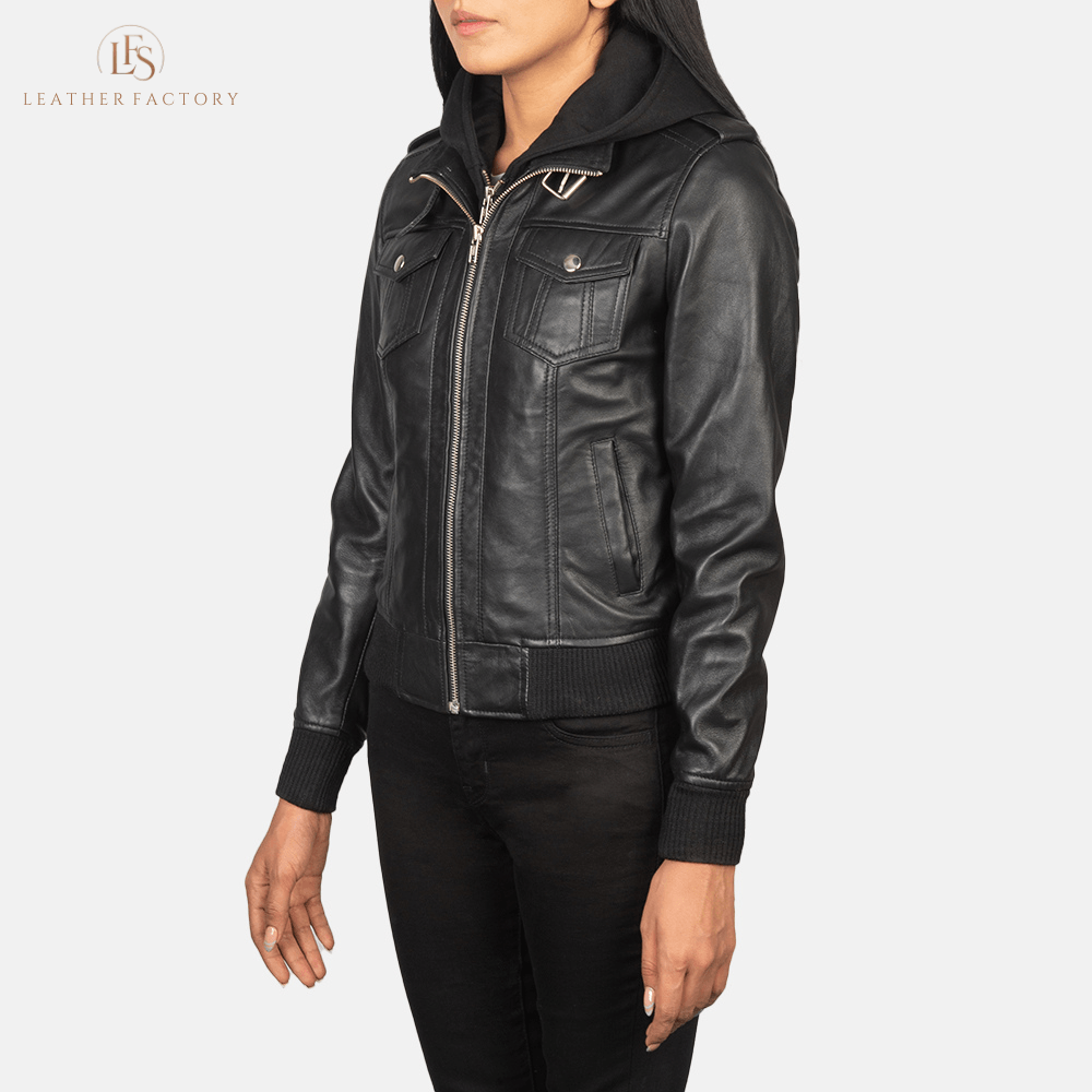 Woman wearing the Roslyn black sheepskin hooded leather bomber jacket featuring a high neck with belt, shoulder epaulettes, and a removable fabric hood.